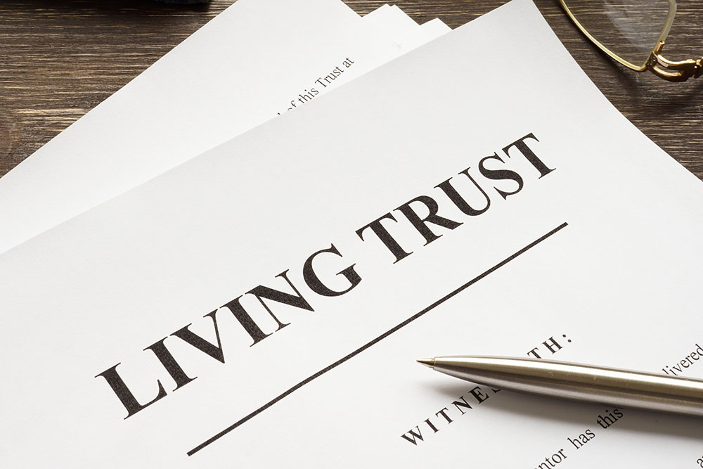 Living trust papers with pen and book.